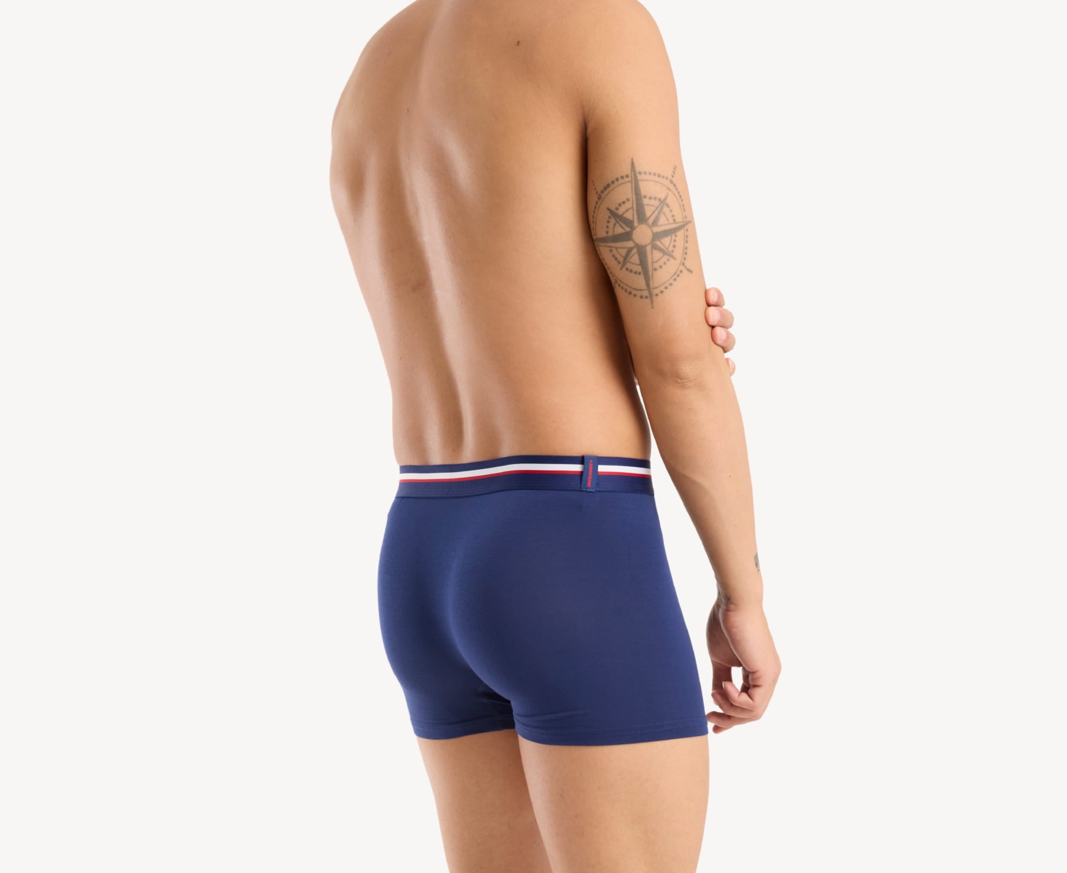 Back view of model wearing men’s 95% micromodal boxer brief in navy with striped navy waistband and rear detail
