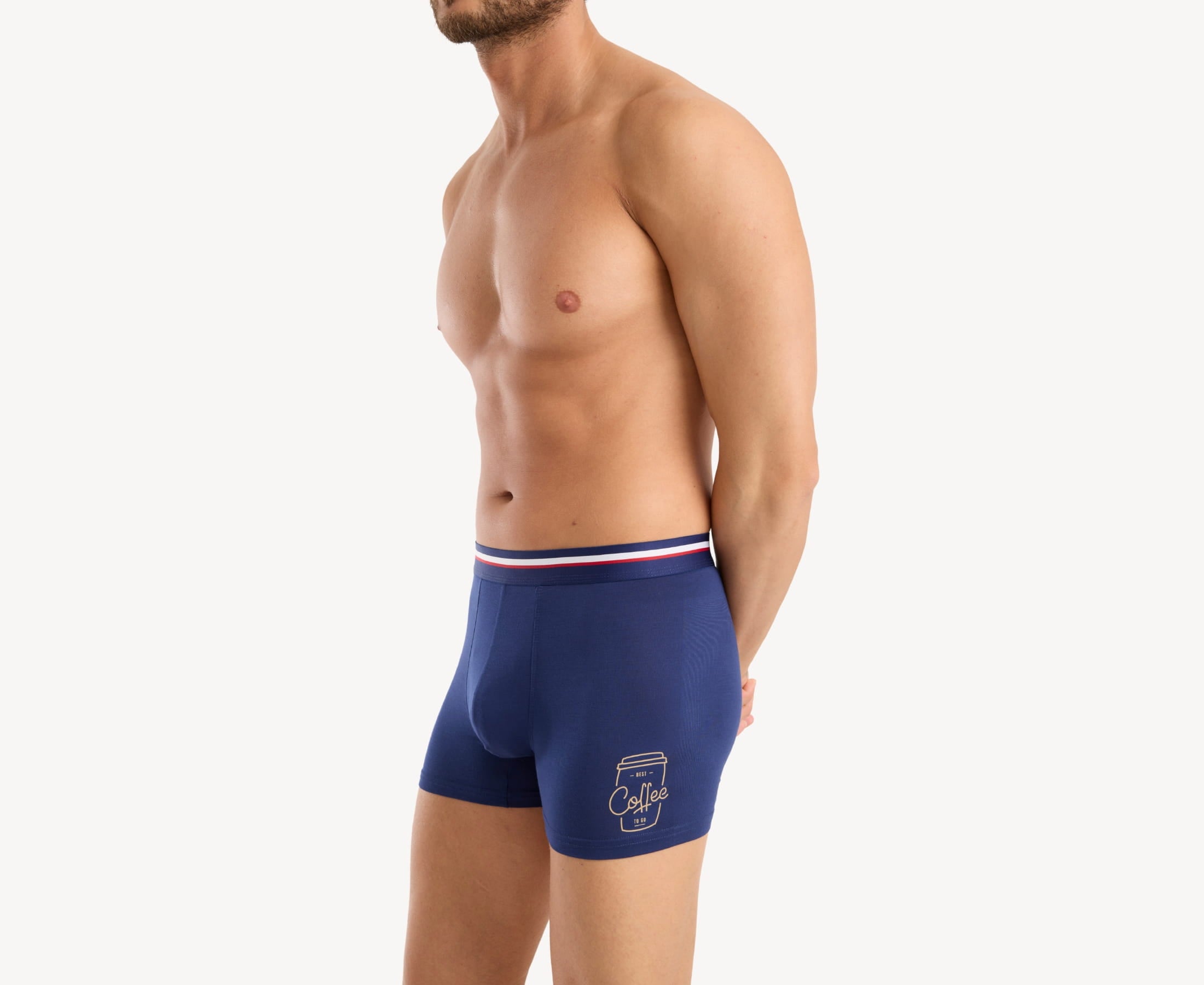 Side view of model wearing men’s 95% micromodal boxer brief in navy with coffee cup print, contoured pouch, and tailored leg cut
