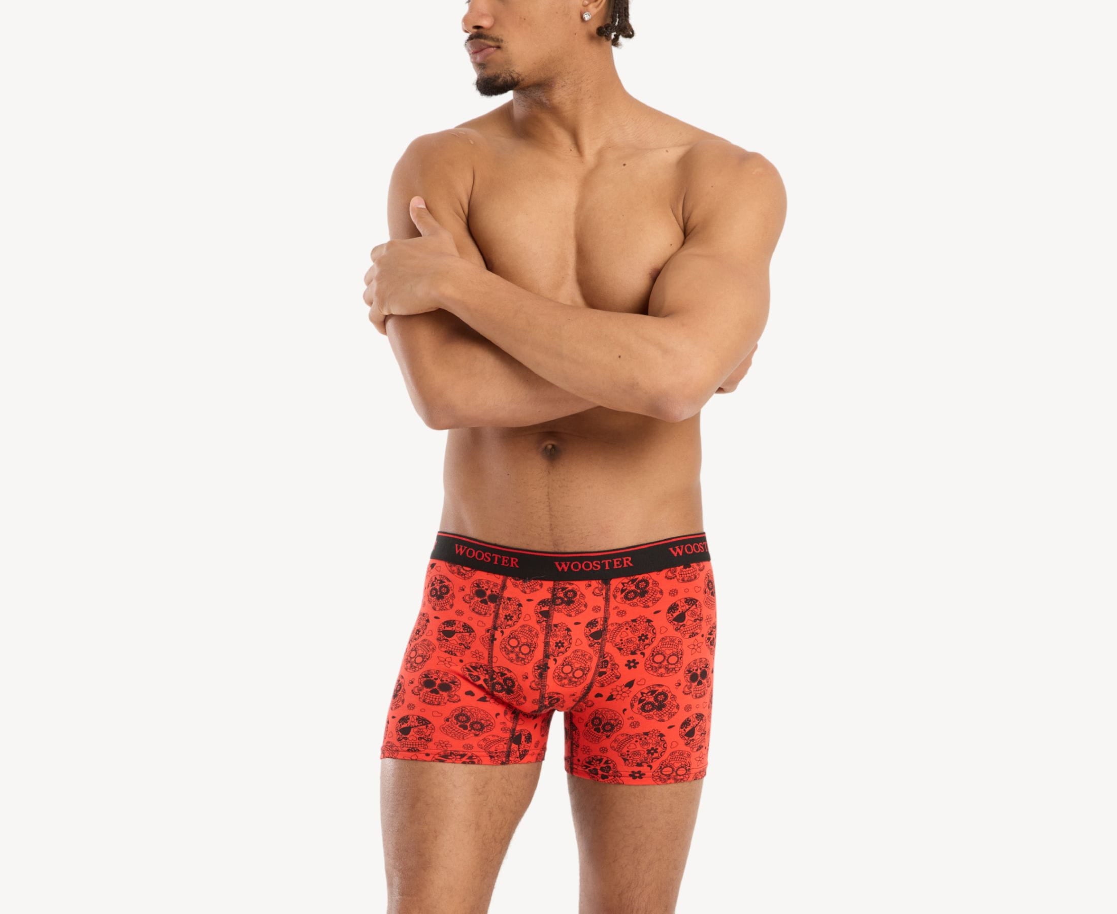 Front view of model wearing men’s 95% cotton crimson red boxer brief with black skulls in bloom print, relaxed fit, soft stretch cotton, and no-roll waistband