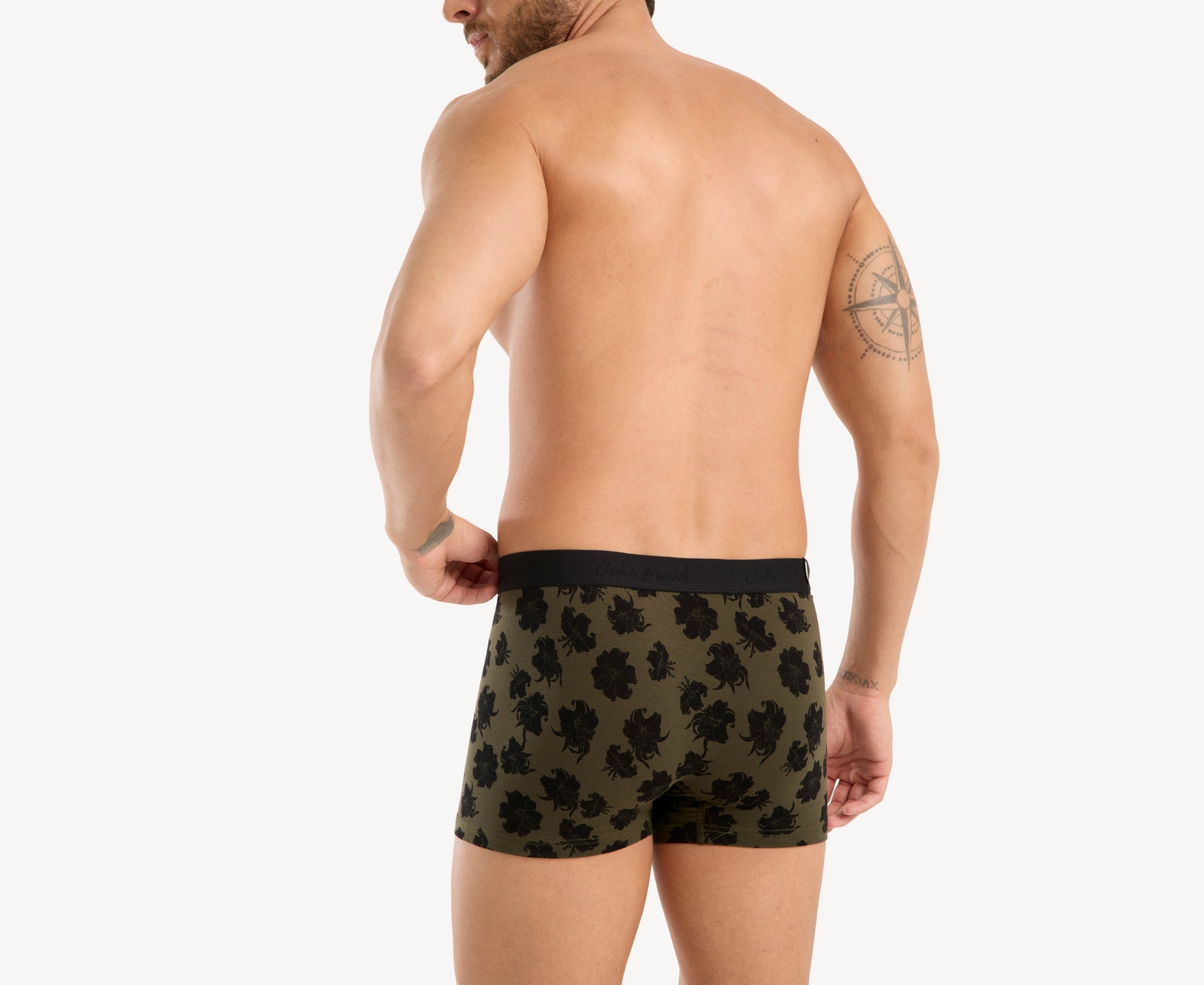 Back view of model wearing men’s 95% cotton boxer brief in olive with black hibiscus print, no-roll waistband, and clean rear detail