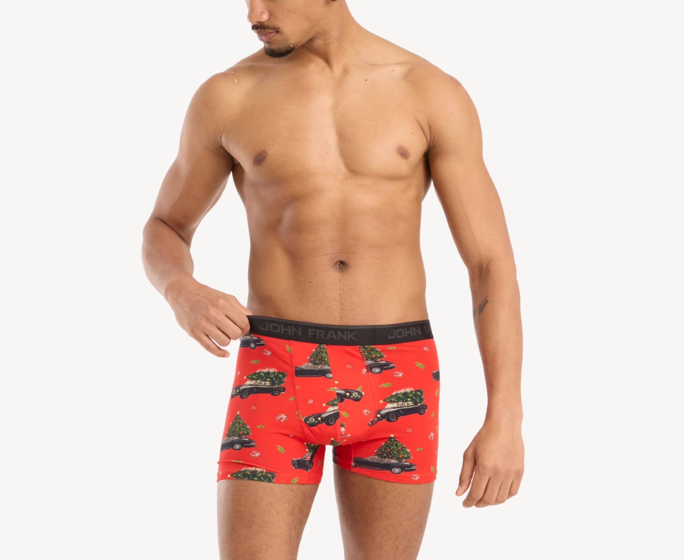Front view of male model wearing men’s 95% cotton boxer brief in red with Christmas tree shopping print, showing smooth waistband and contoured fit
