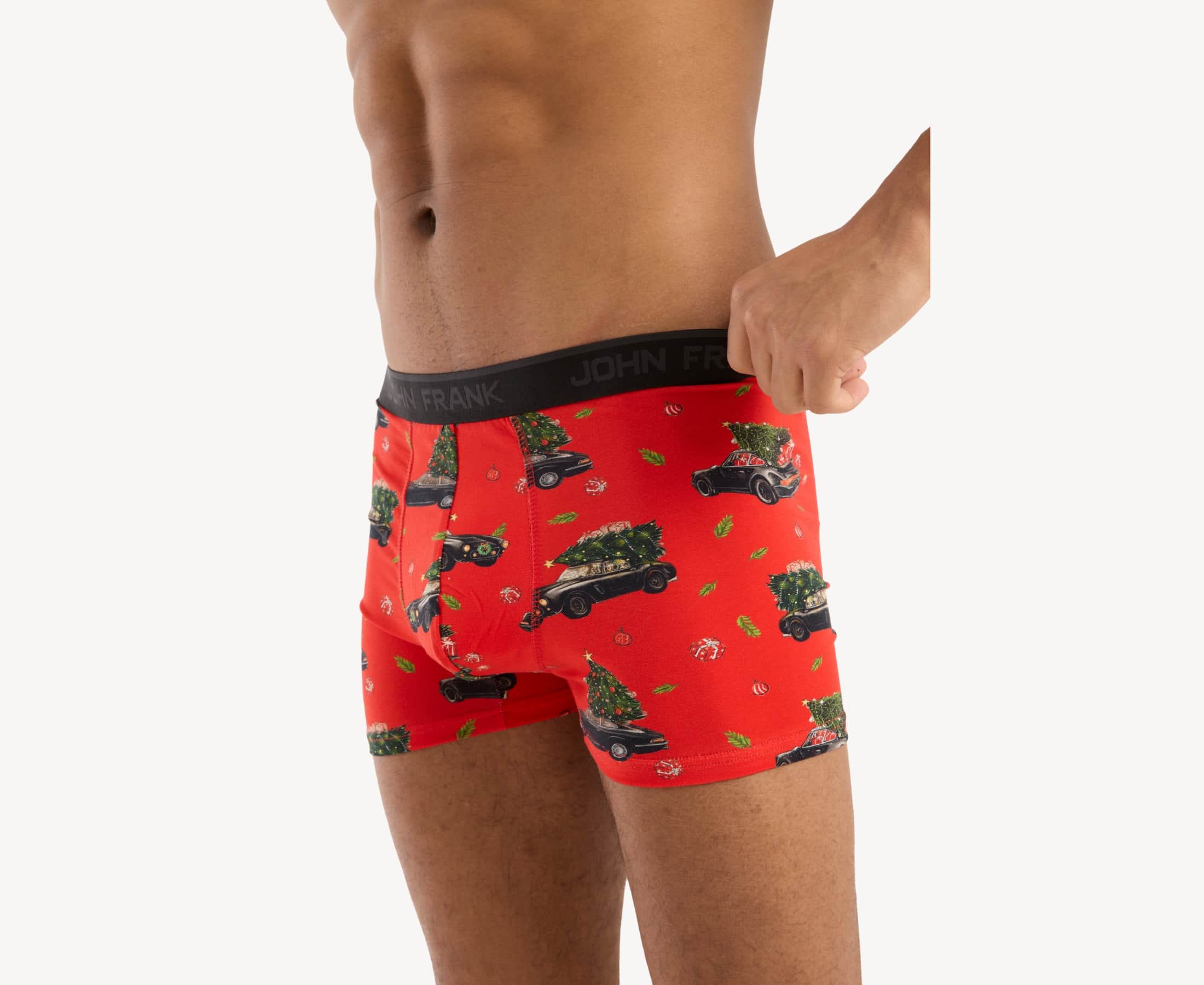 Front side view of male model wearing men’s 95% cotton boxer brief in red with Christmas tree shopping print, showing smooth waistband and contoured fit