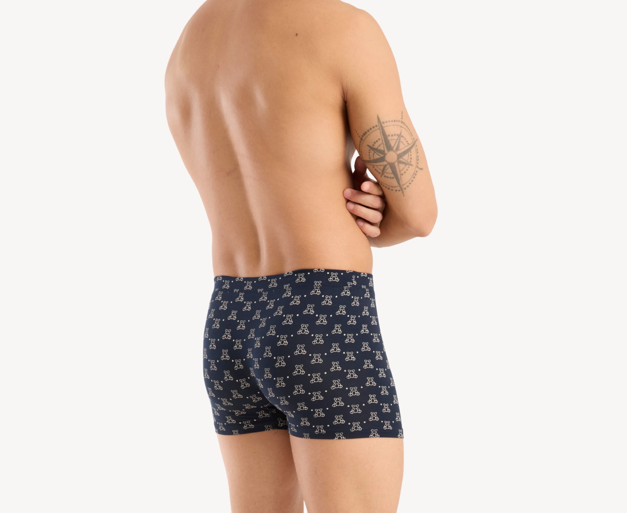 Back view of model wearing men’s 95% micromodal boxer brief in navy with teddy bear print, smooth fabric-covered waistband and rear detail