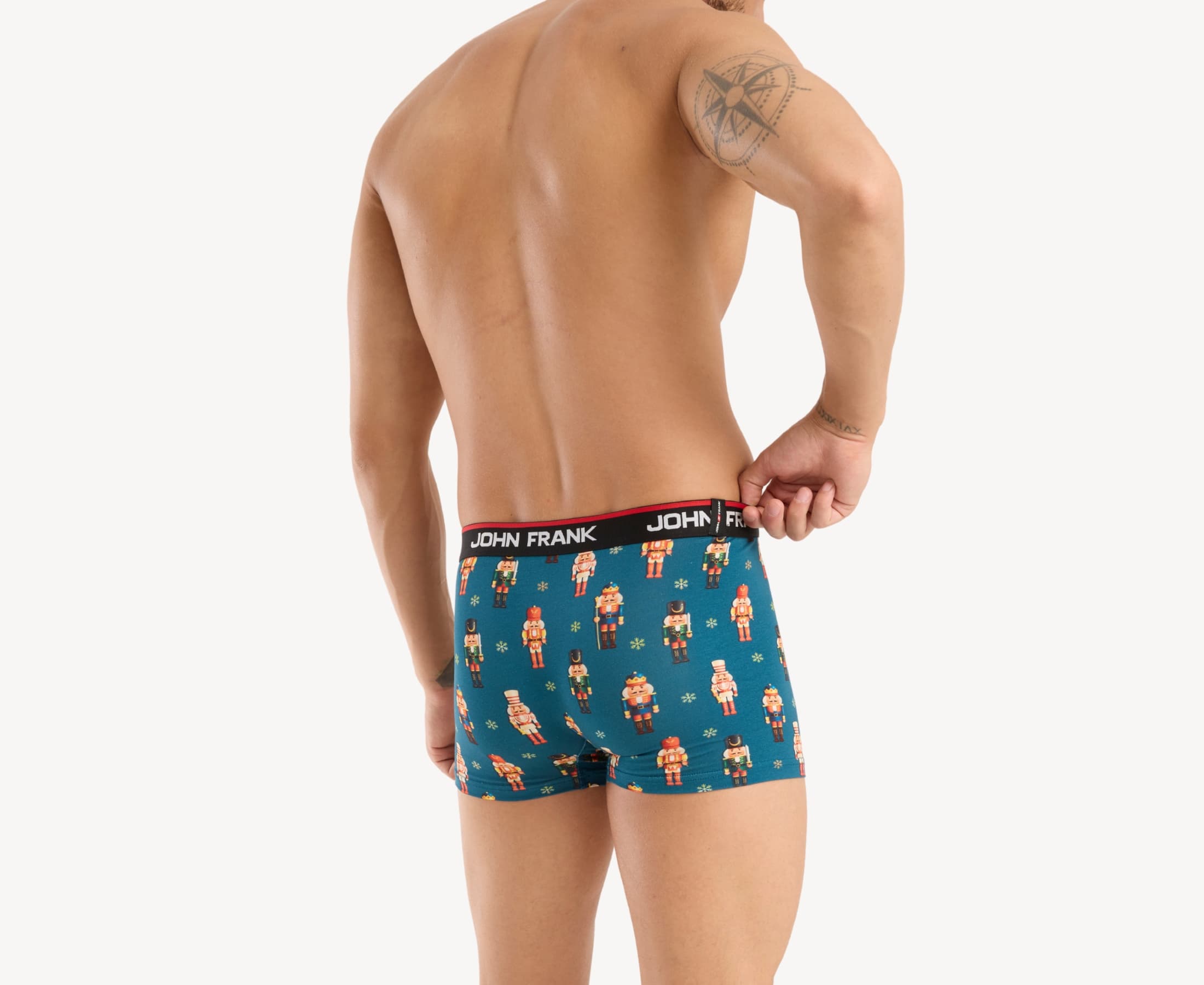 Back view of male model wearing men’s 95% cotton boxer brief in teal with colorful nutcrackers print, showing waistband detail
