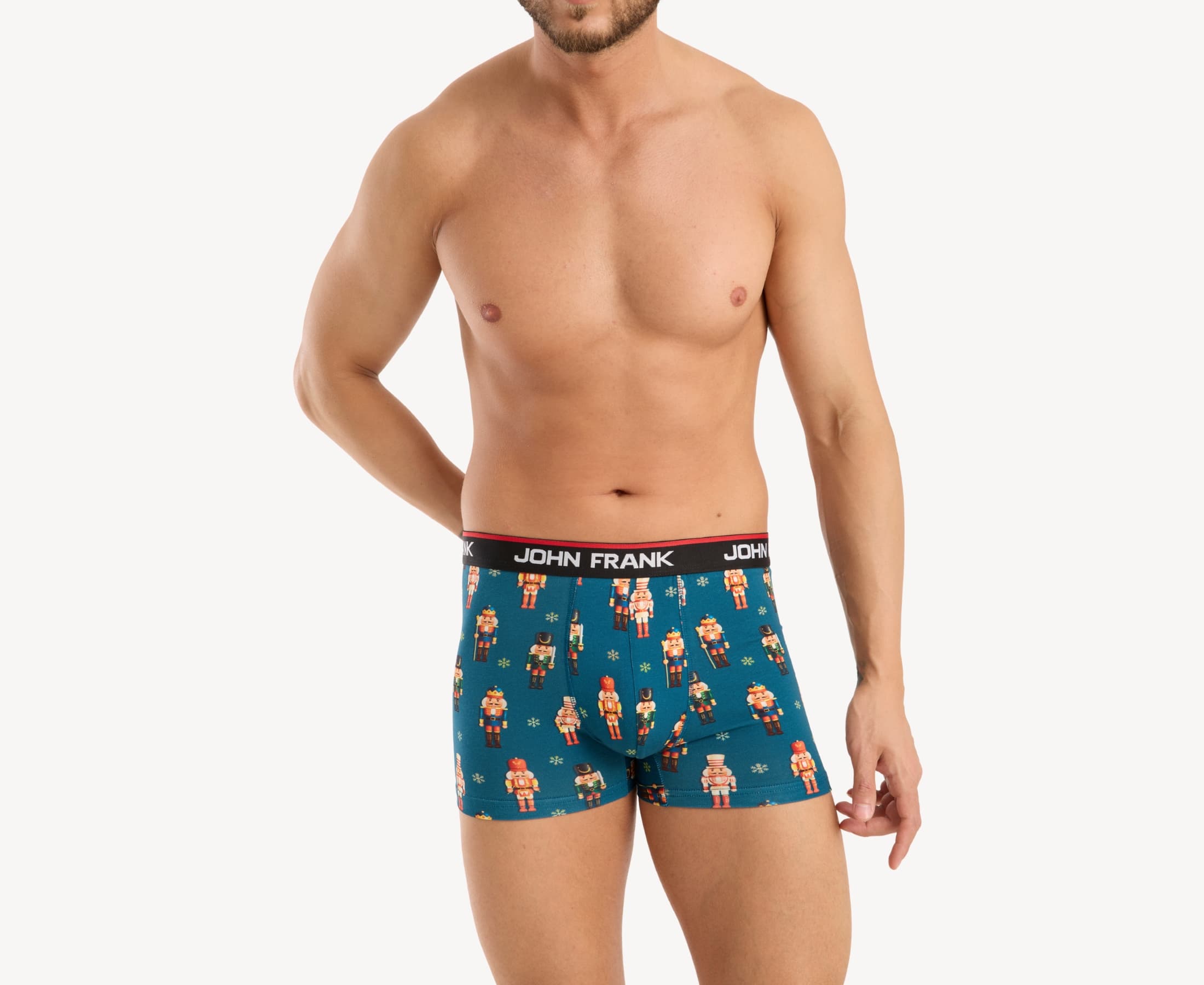Front view of male model wearing men’s 95% cotton boxer brief in teal with colorful nutcrackers print, showing smooth waistband and contoured fit