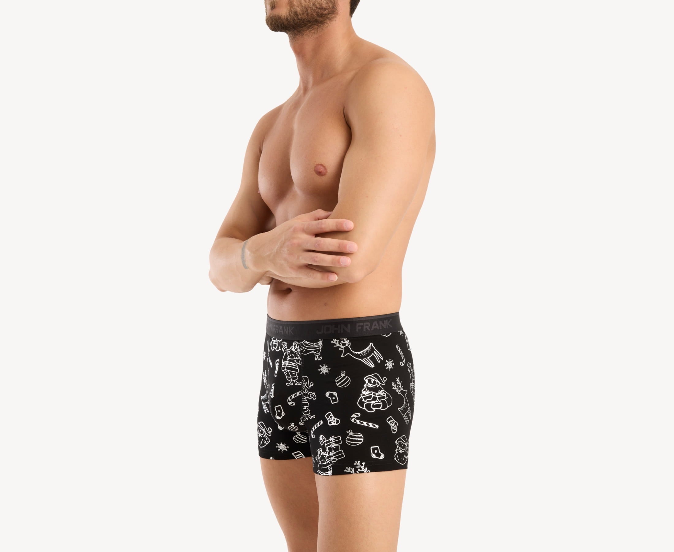 Front side view of male model wearing men’s 95% cotton boxer brief in black with shiny silver Christmas doodles print, showing smooth waistband and contoured fit