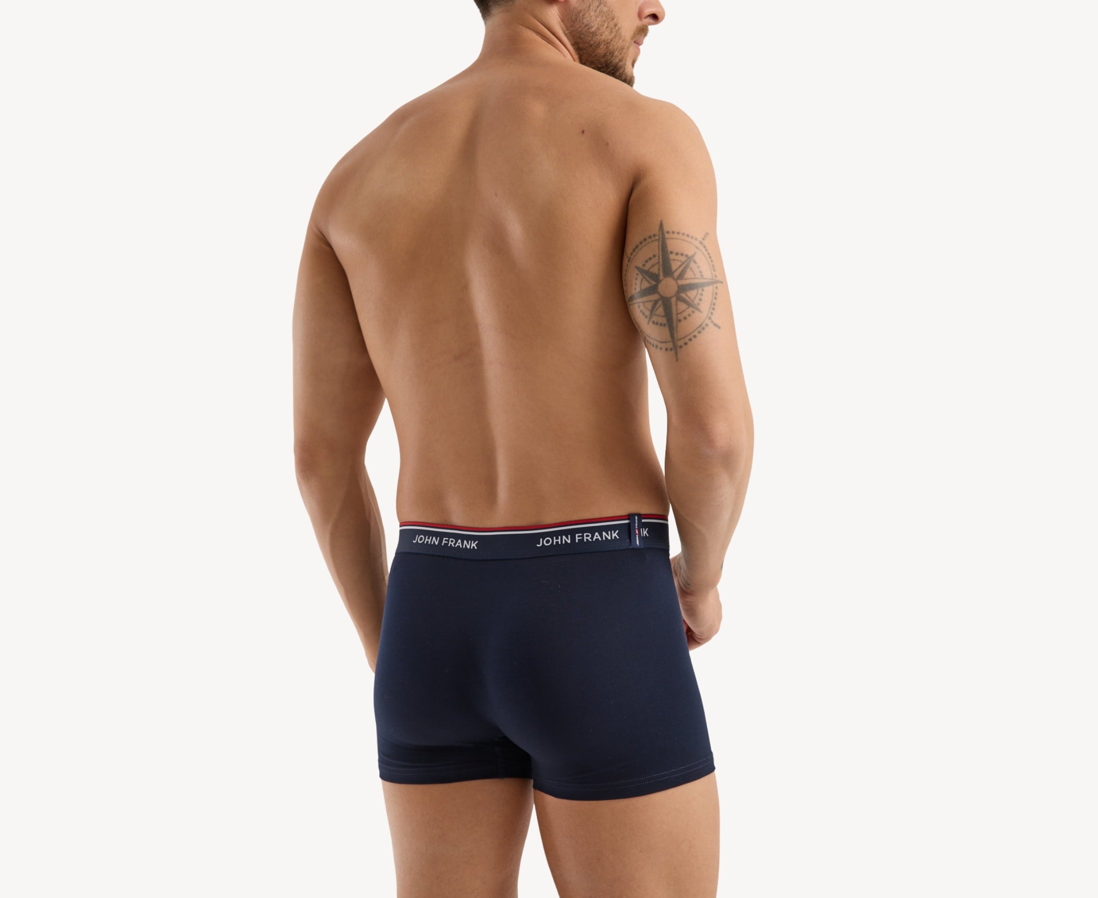 Back view of model wearing men’s 95% cotton boxer brief in midnight blue with midnight blue striped waistband and rear detail