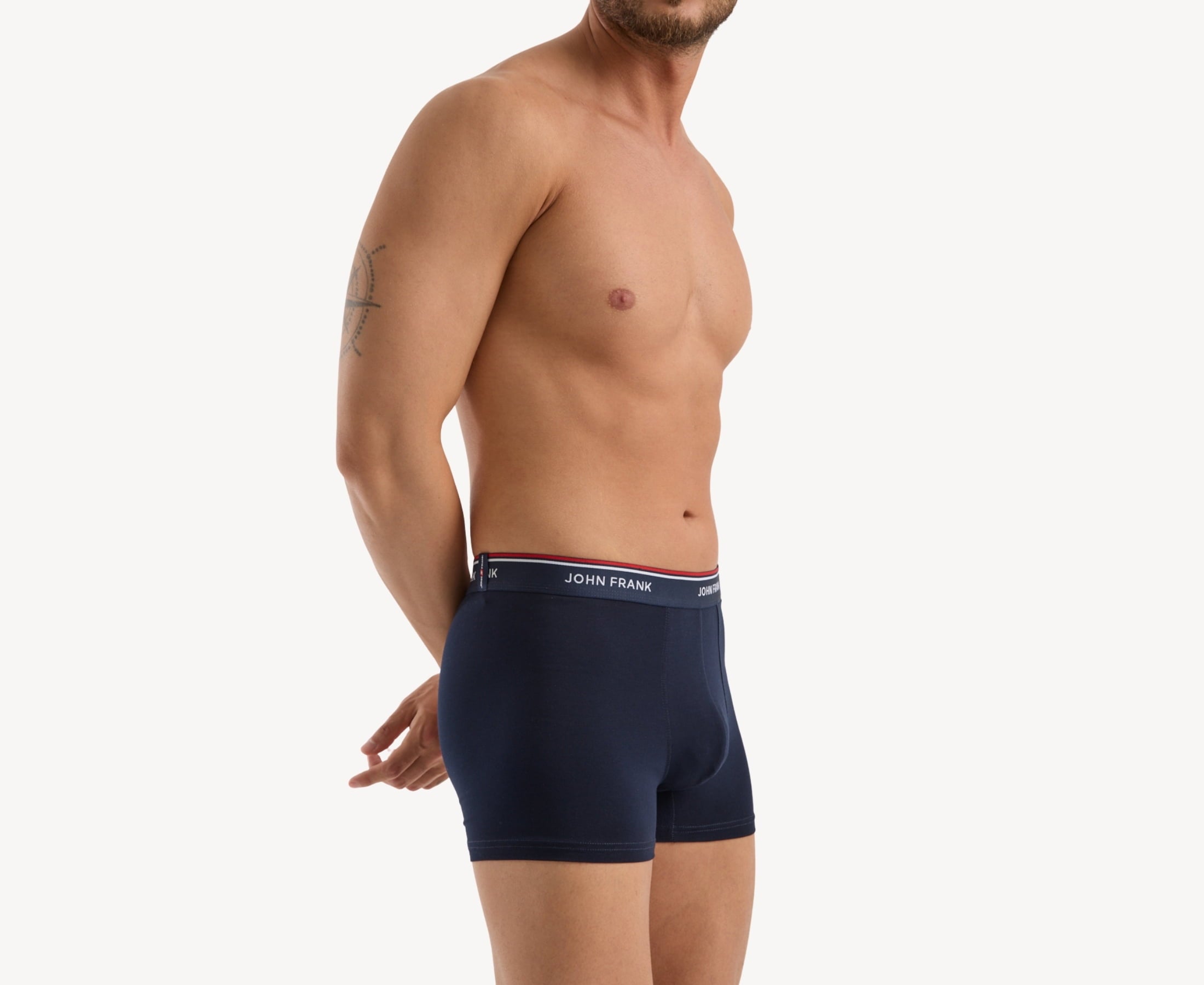 Side view of model wearing men’s 95% cotton boxer brief in midnight blue with midnight blue striped waistband, contoured pouch, and tailored leg cut