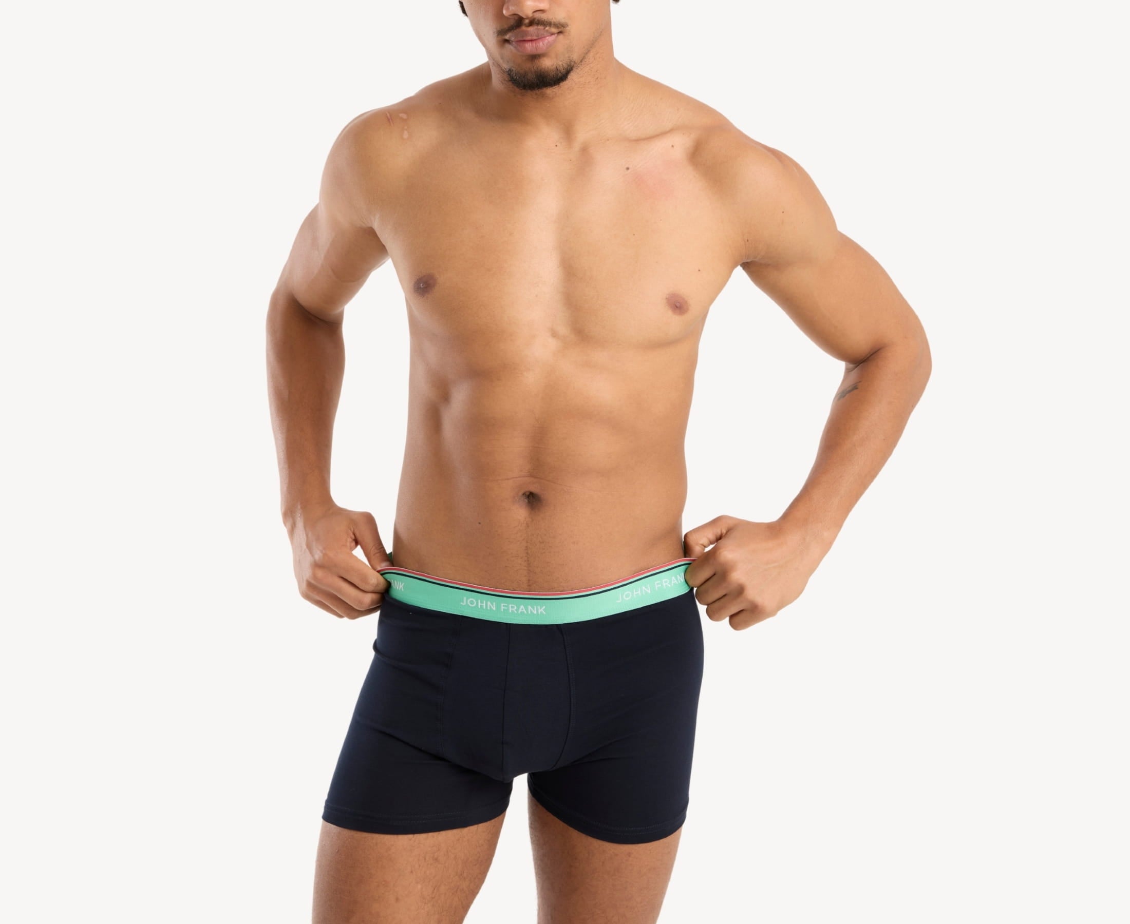 Front view of model wearing men’s 95% cotton boxer brief in midnight blue with sea green striped waistband and soft stretch