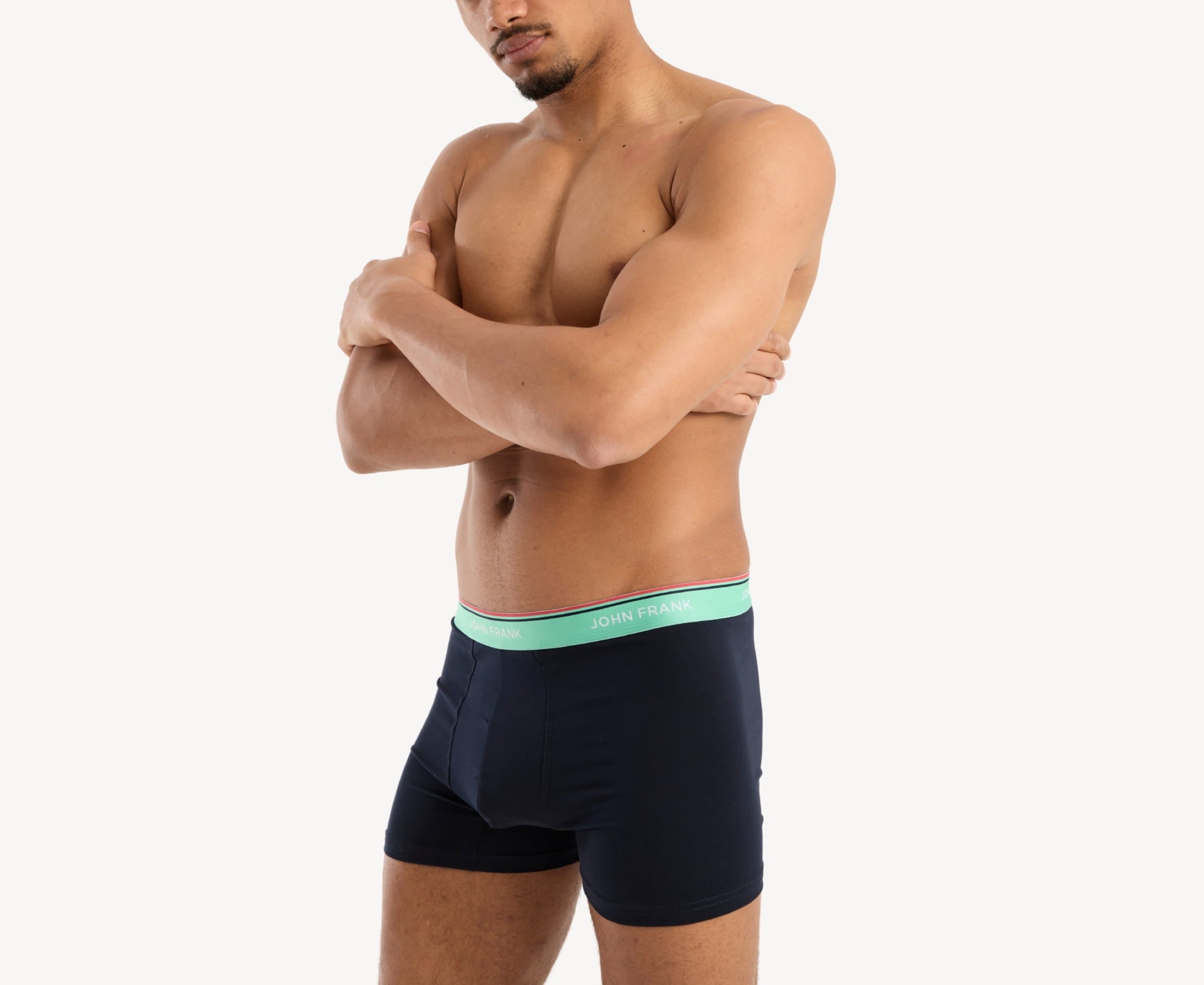 Side view of model wearing men’s 95% cotton boxer brief in midnight blue with sea green striped waistband, contoured pouch, and tailored leg cut