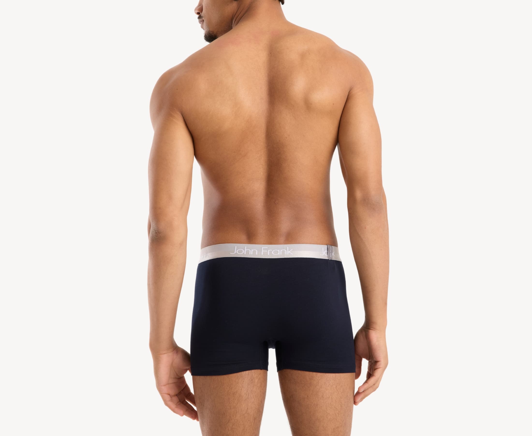 Back view of model wearing men’s 95% cotton boxer brief in navy with white shiny waistband and rear detail