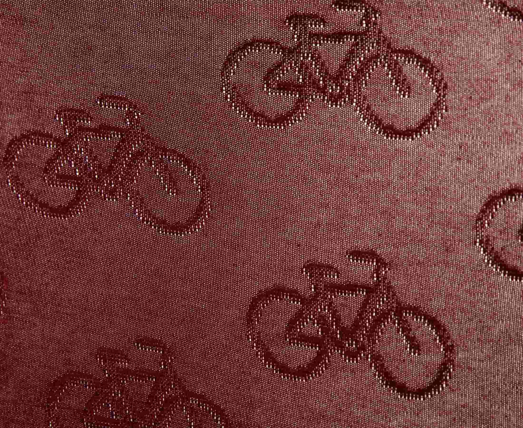 Detailed view of burgundy fabric with jacquard bicycles pattern
