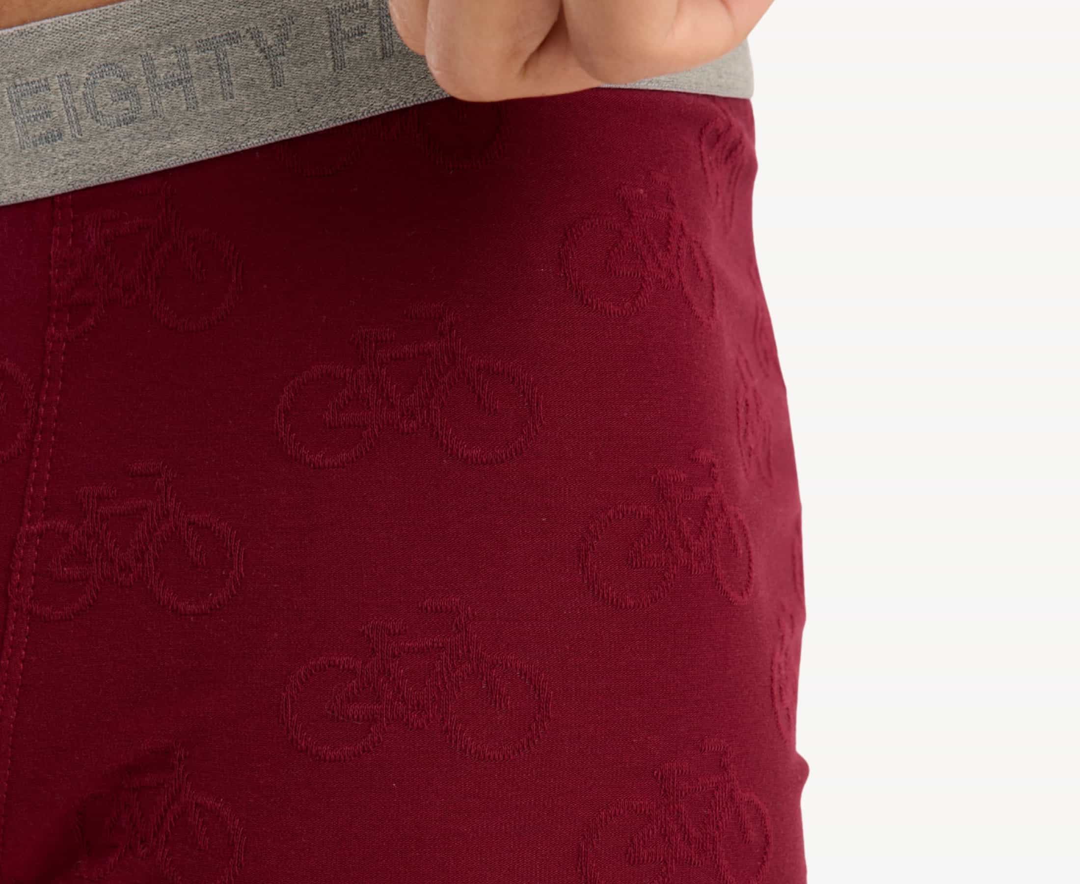 Close-up view of men’s 95% cotton boxer brief in burgundy with jacquard bicycles print, showcasing palms pattern and smooth no-roll waistband