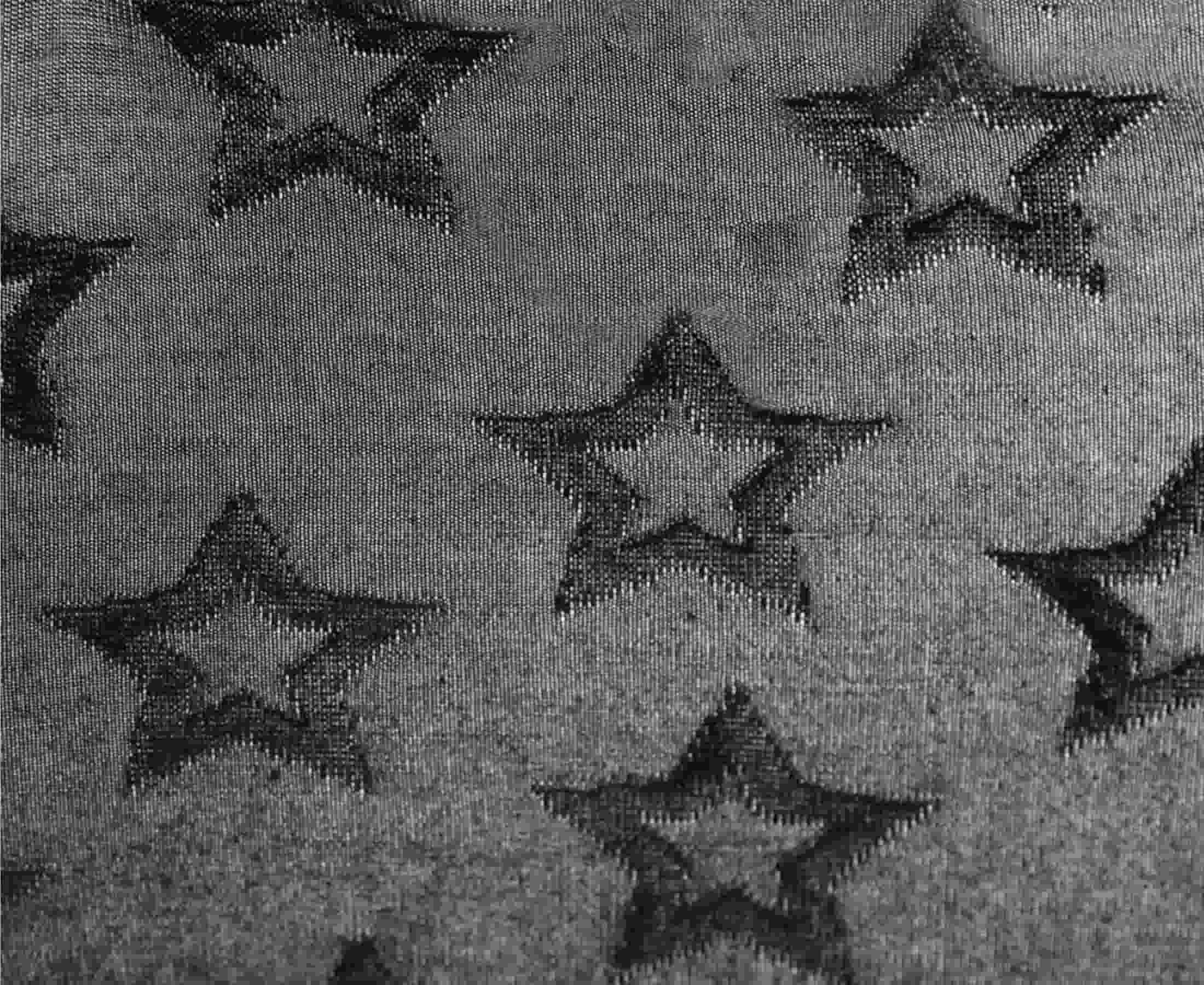 Detailed view of black fabric with jacquard stars pattern