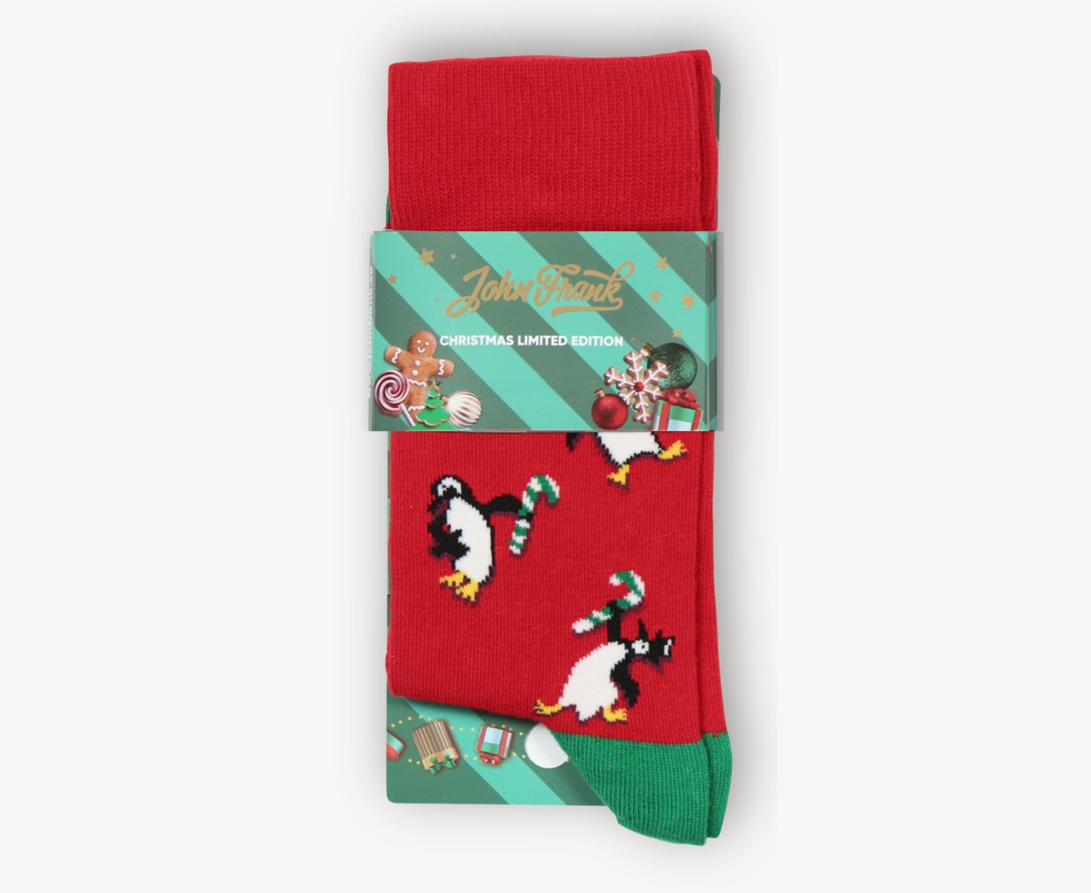 Gift packaging view of men’s 80% cotton crew socks in red with penguin and candy cane design, folded with green toe and cuff, wrapped in festive band