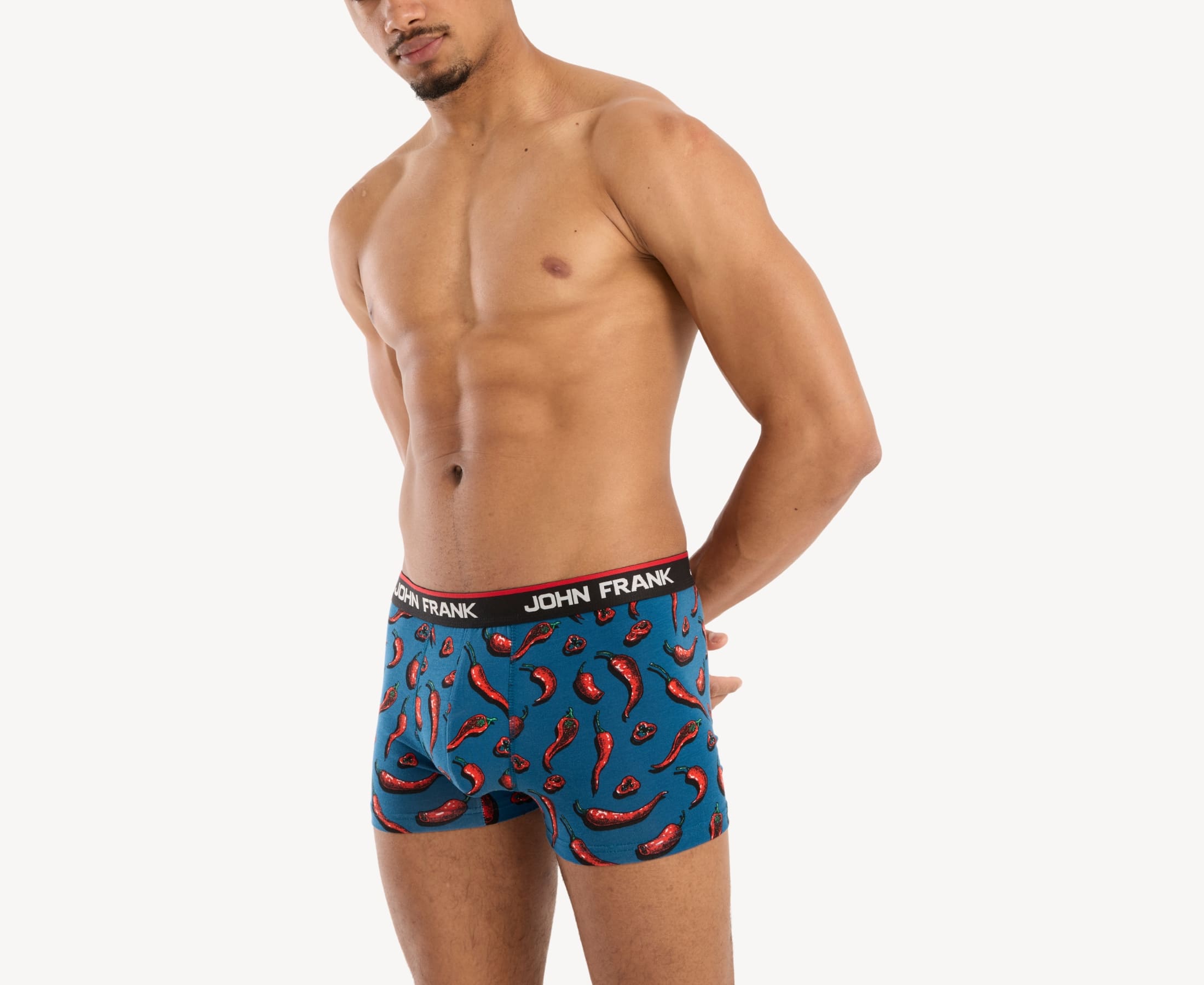 Front side view of male model wearing men’s 95% cotton boxer brief in blue with red hot chili pepper print, showing smooth waistband and contoured fit