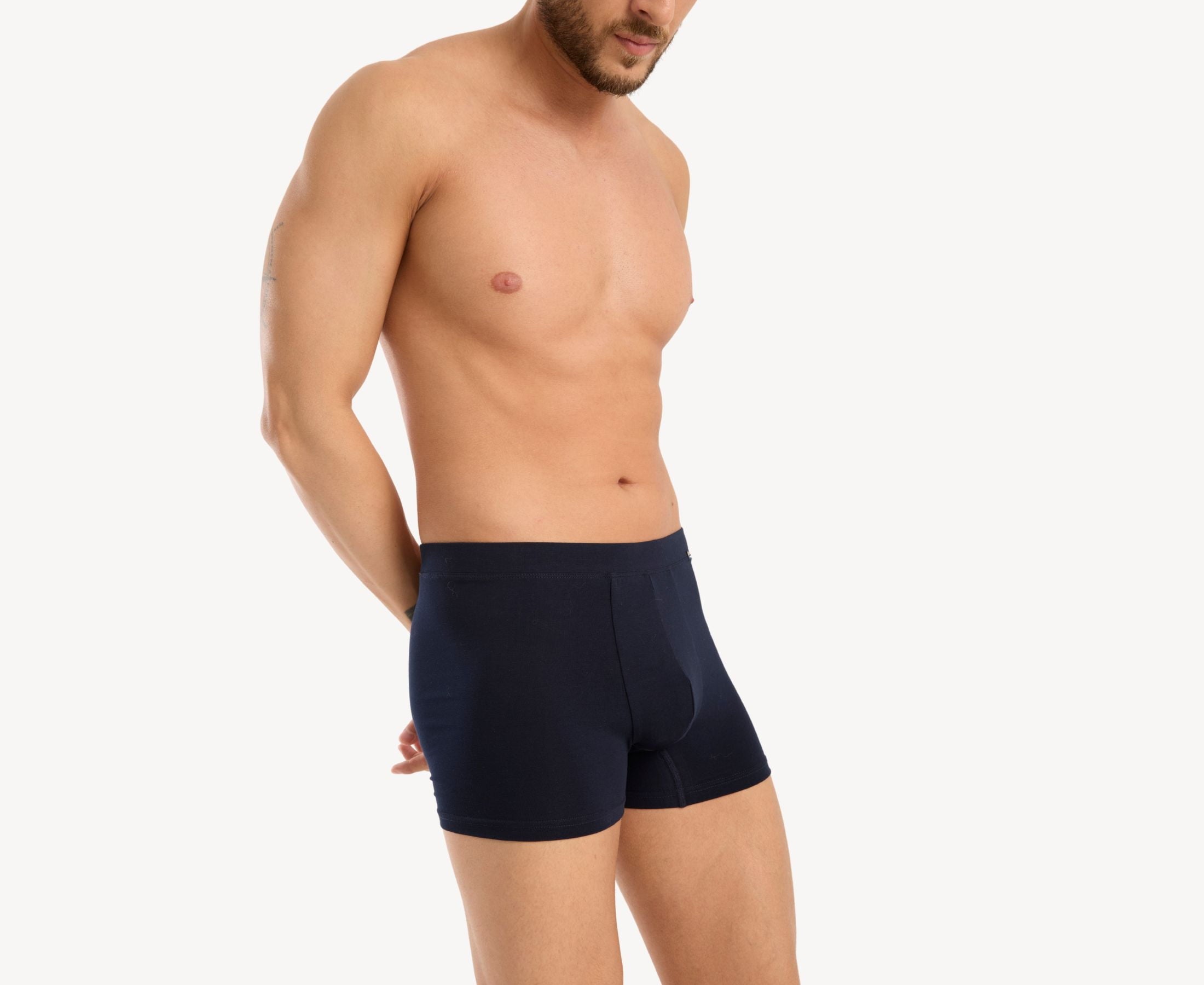 Side view of model wearing men’s 95% cotton boxer brief in navy with fabric-covered waistband, contoured pouch, and tailored leg cut