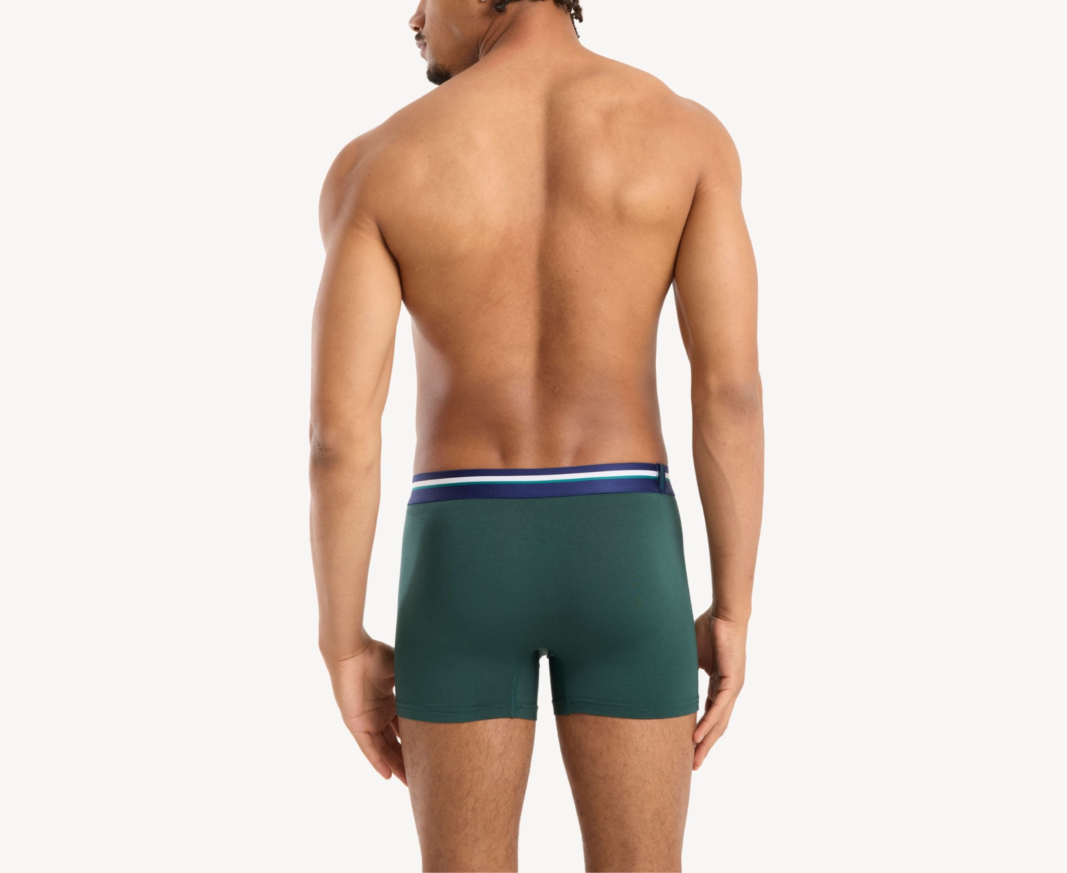 Back view of model wearing men’s 95% micromodal boxer brief in emerald green with striped navy waistband and rear detail