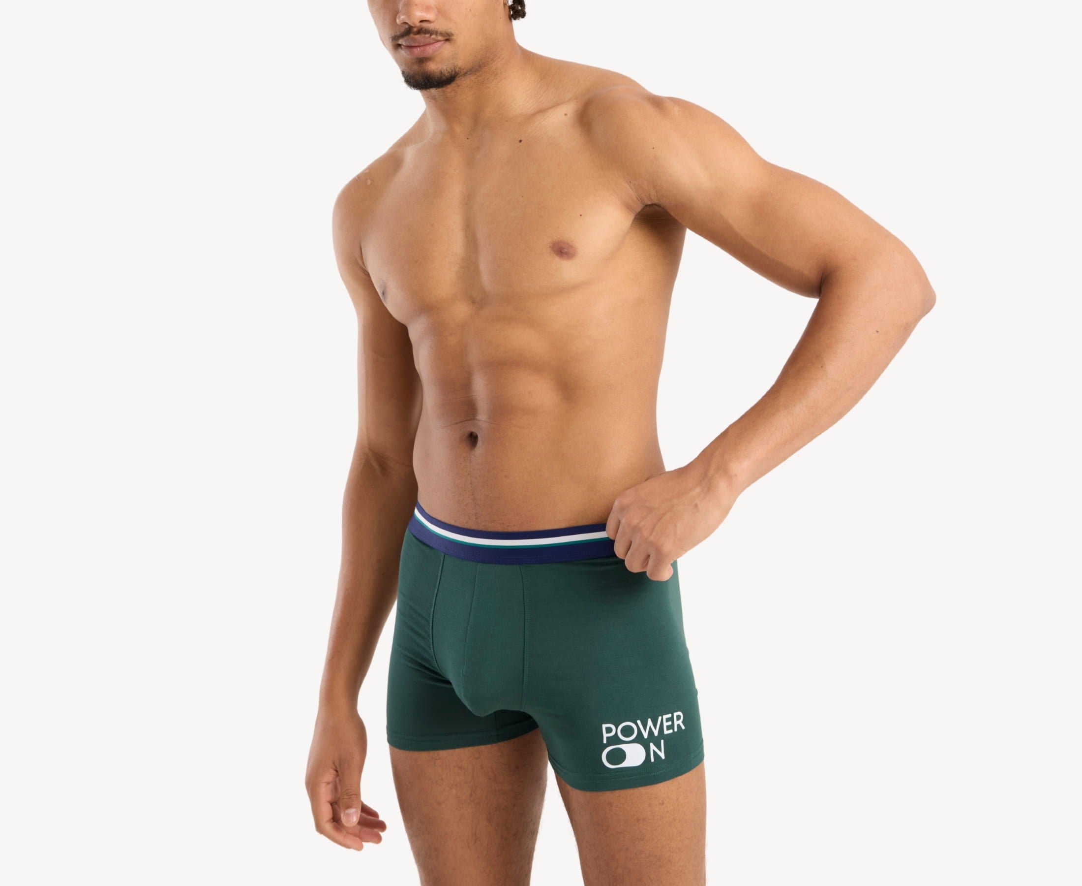 Side view of model wearing men’s 95% micromodal boxer brief in emerald green with power-on print, contoured pouch, and tailored leg cut