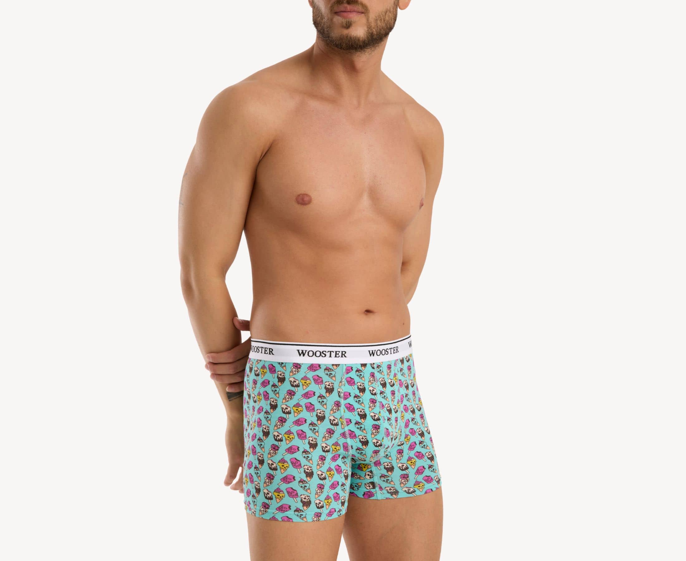 Side view of model wearing men’s 95% cotton teal boxer brief with multicolor ice cream skulls print, relaxed fit, vibrant colors, and smooth rear panel