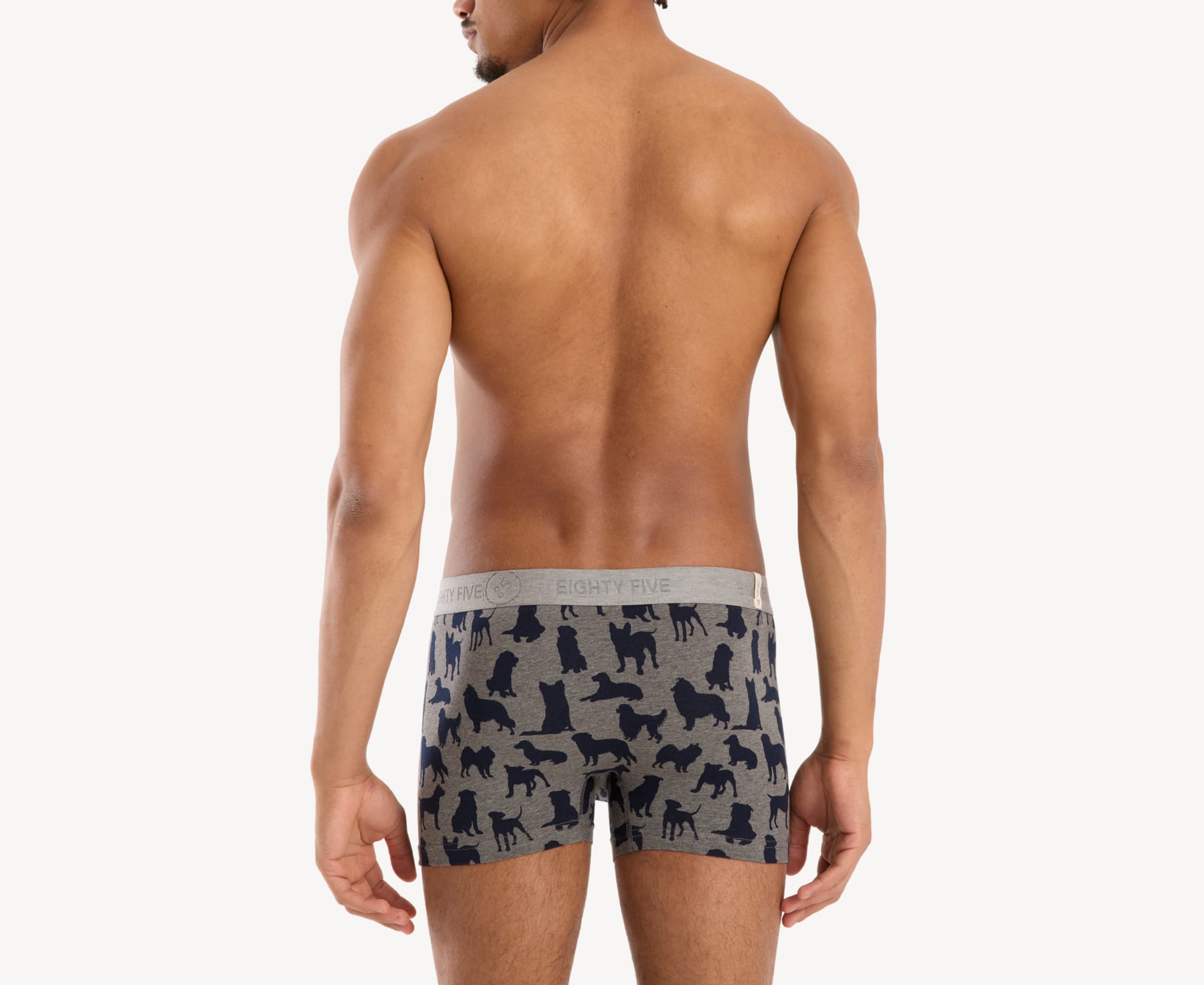 Back view of male model wearing men’s 95% cotton boxer brief in heather gray with navy dog silhouette print, showing smooth waistband and contoured fit.