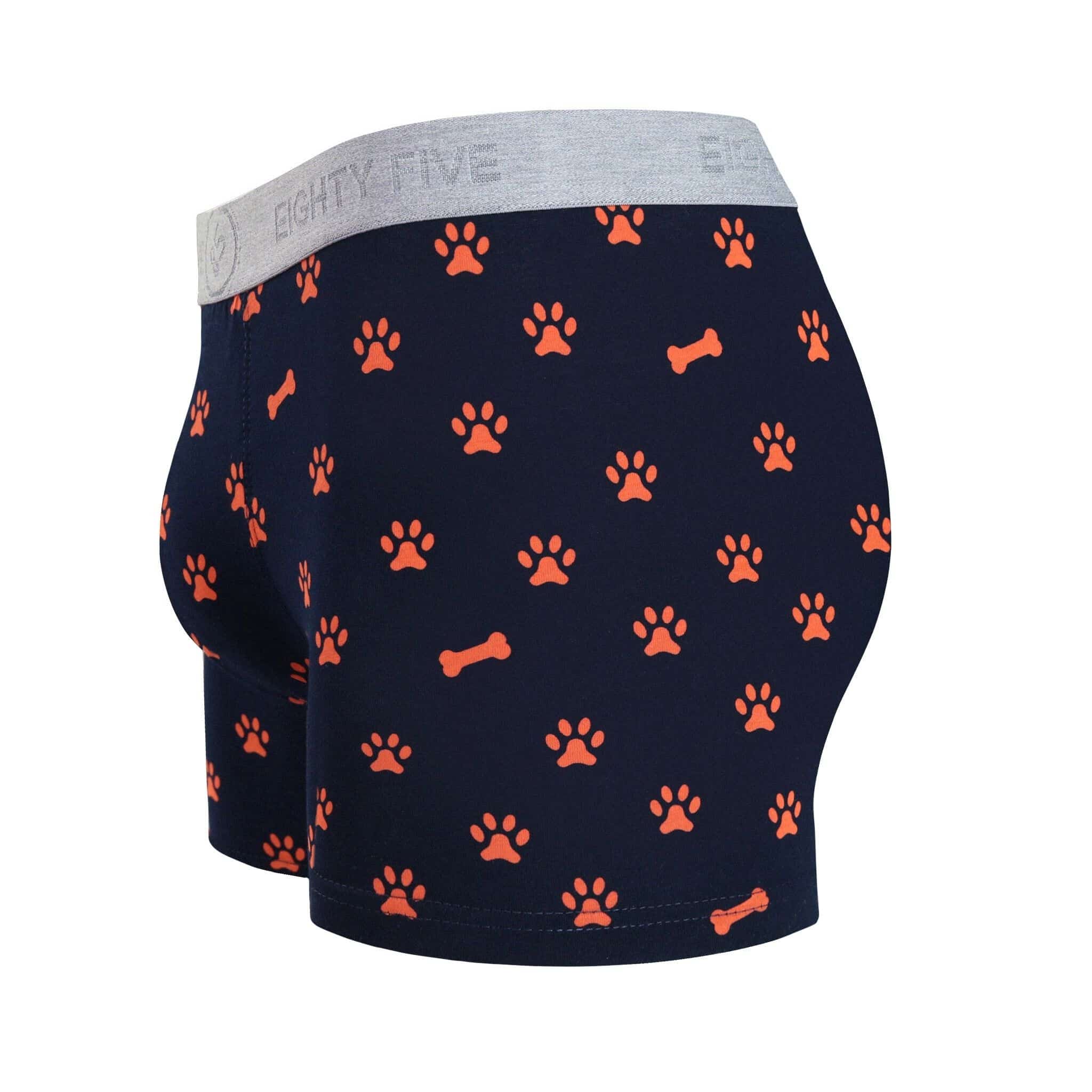 Side view of men’s 95% cotton boxer brief in navy with orange paws and bones print, contoured pouch, and tailored leg cut