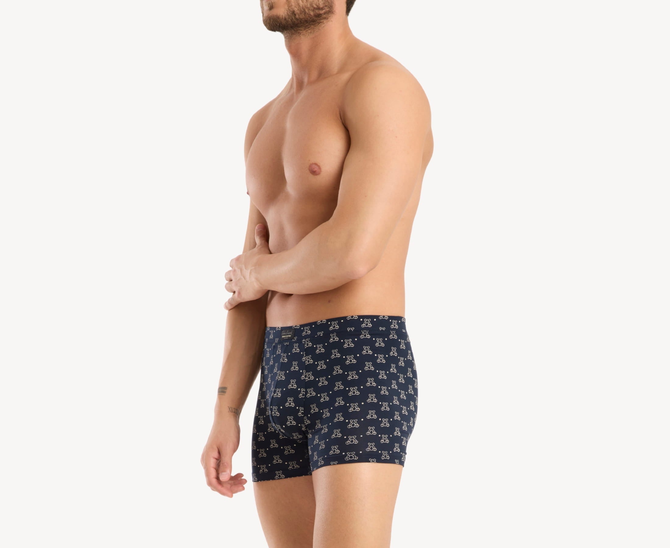 Side view of model wearing men’s 95% micromodal boxer brief in navy with teddy bear print, contoured pouch and tailored leg cut
