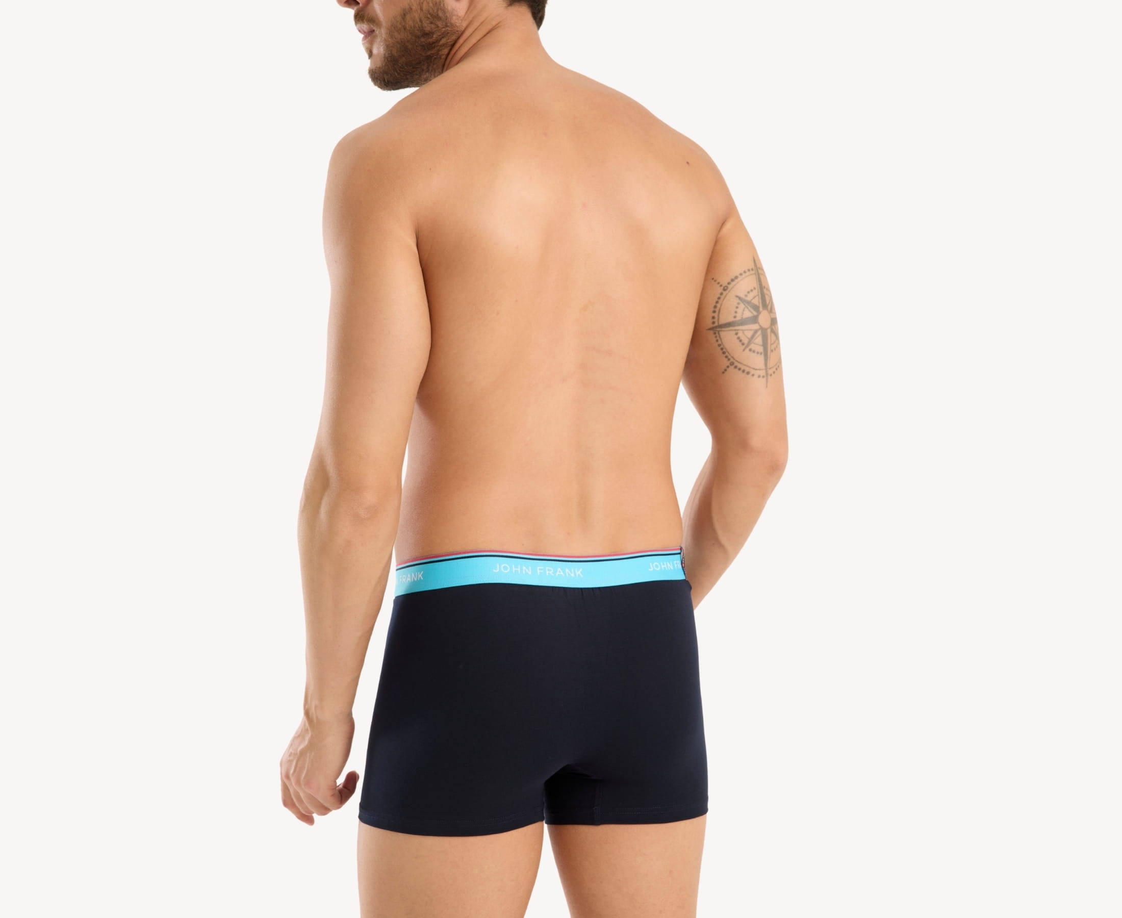 Back view of model wearing men’s 95% cotton boxer brief in midnight blue with turquoise striped waistband and rear detail