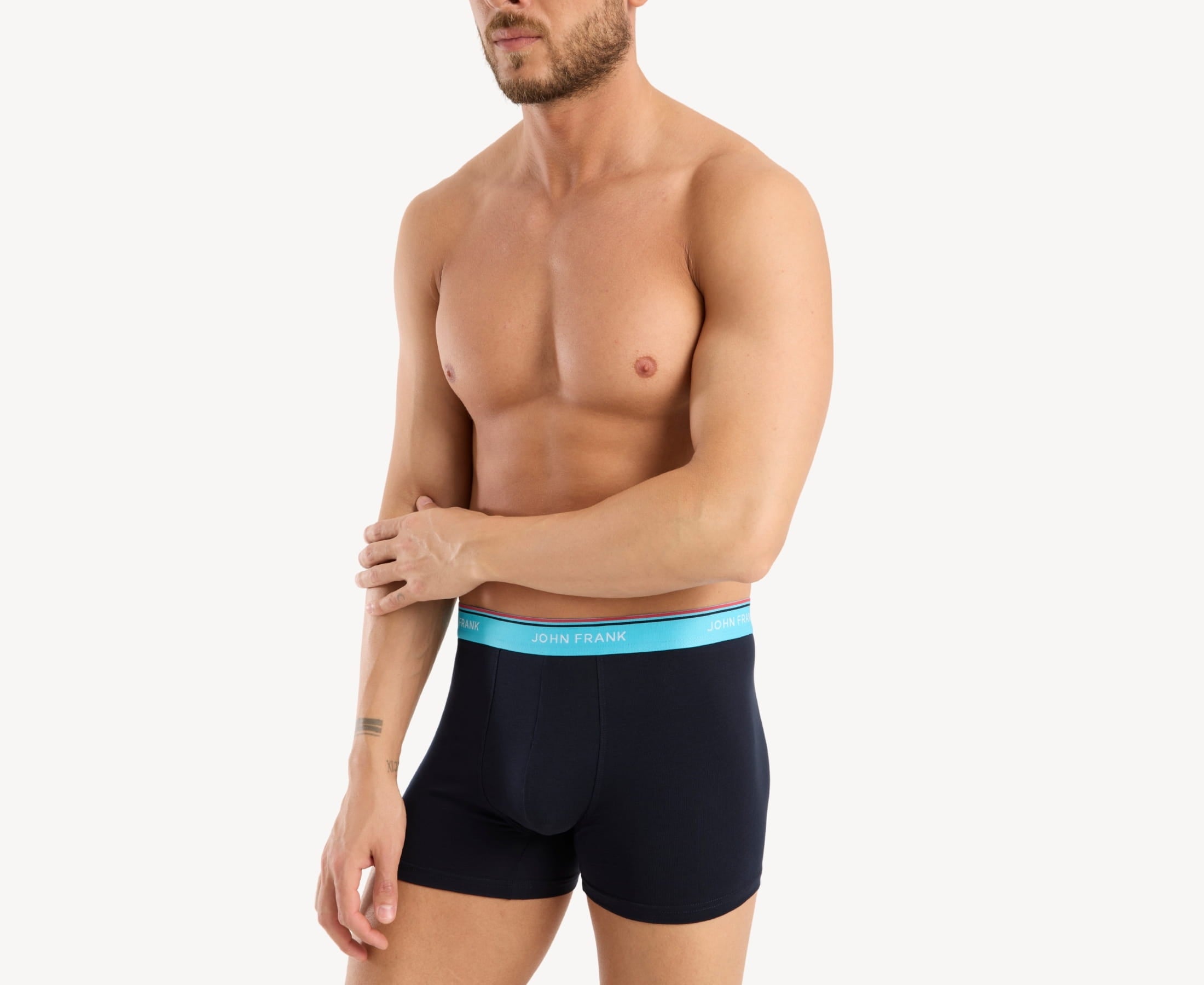 Side view of model wearing men’s 95% cotton boxer brief in midnight blue with turquoise striped waistband, contoured pouch, and tailored leg cut