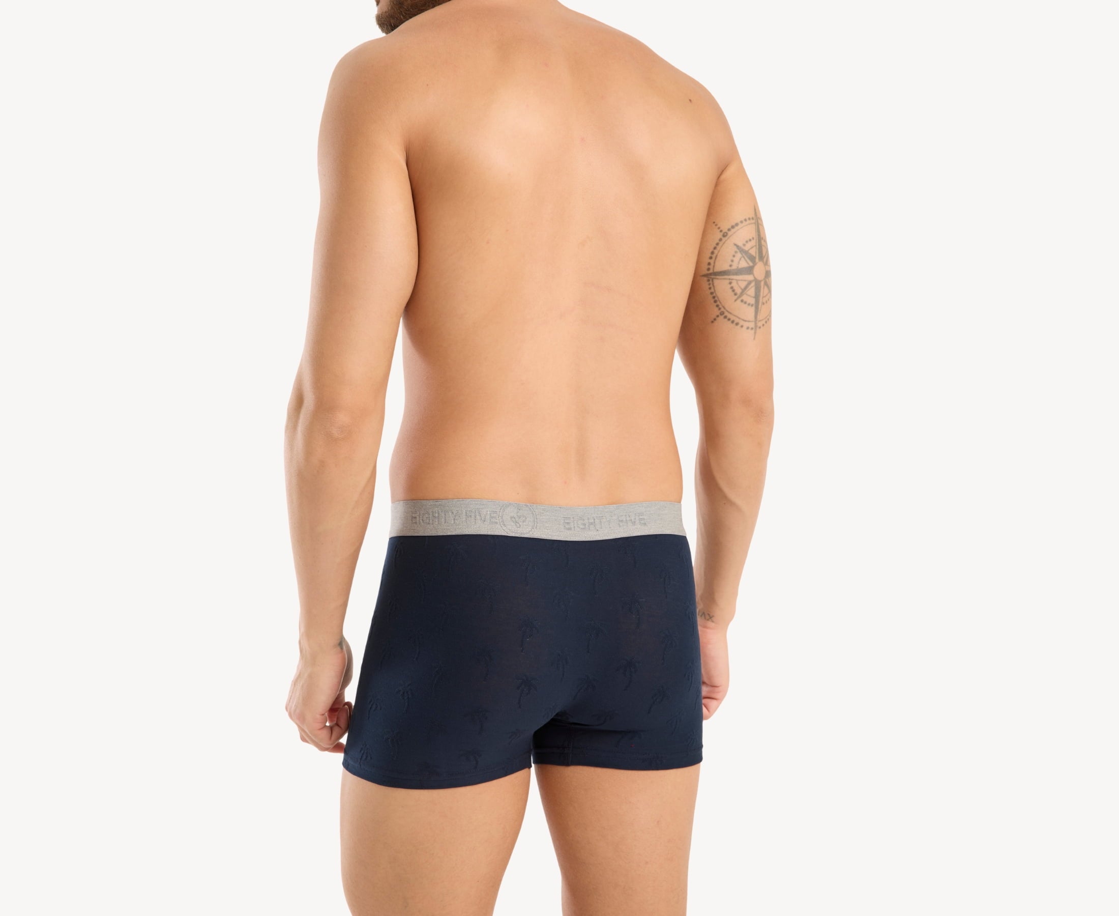 Back view of model wearing men’s 95% cotton boxer brief in navy with jacquard palms pattern, showcasing smooth waistband and rear detail