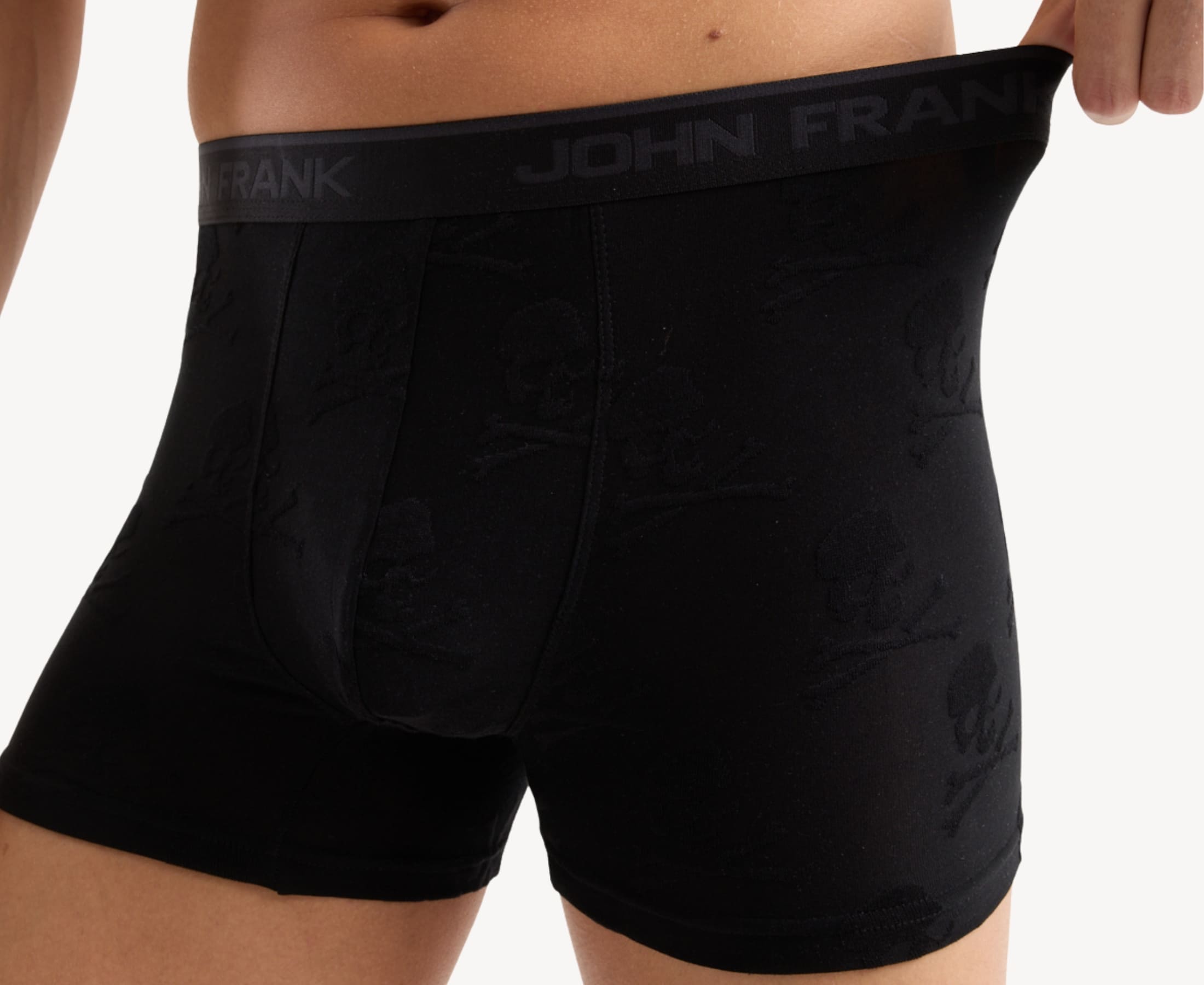 Close-up view of men’s 95% micromodal boxer brief in black with jacquard skull and crossbones pattern, showcasing the smooth no-roll waistband