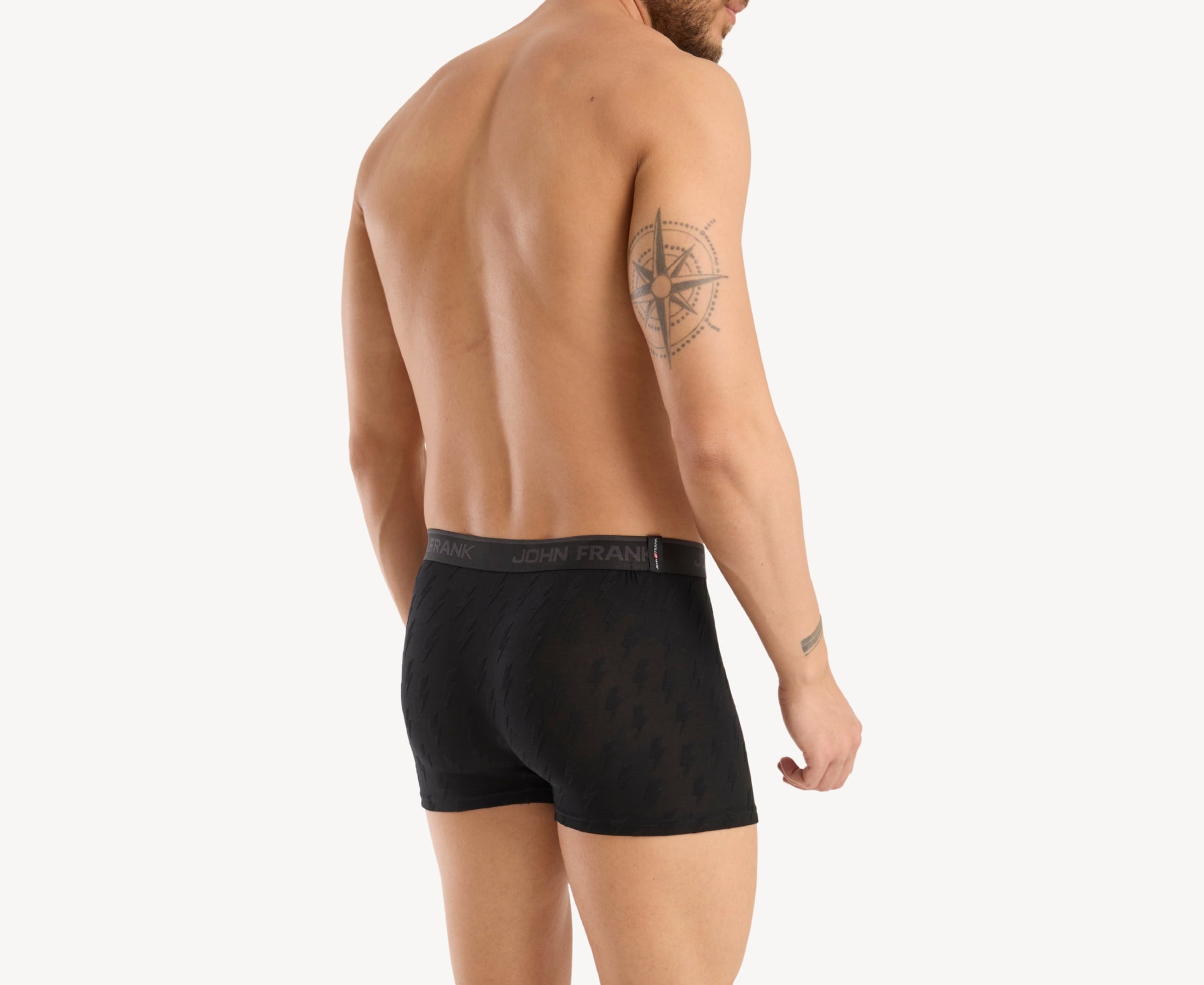 Back view of model wearing men’s 95% micromodal boxer brief in black with jacquard lightening flash pattern, showcasing smooth waistband and rear detail