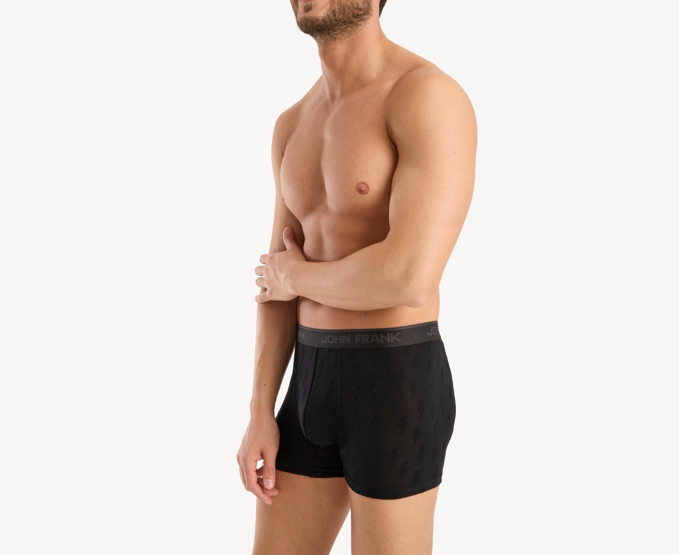 Side view of model wearing men’s 95% micromodal boxer brief in black with jacquard lightening flash pattern, showcasing contoured pouch, and tailored leg cut