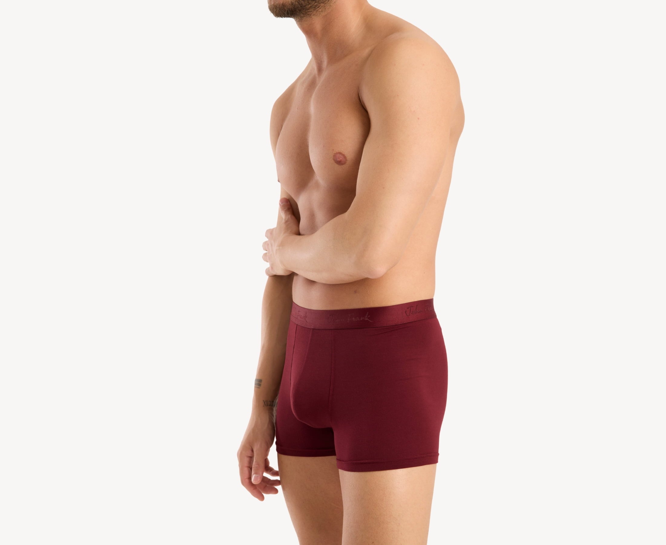 Side view of model wearing men’s 95% micromodal boxer brief in bordeaux with contoured pouch and tailored leg cut