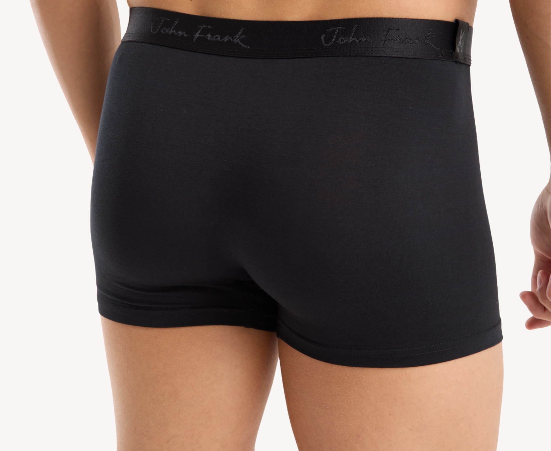 Back view of model wearing men’s 95% micromodal boxer brief in pitch black with tonal waistband featuring subtle sheen and clean rear detail