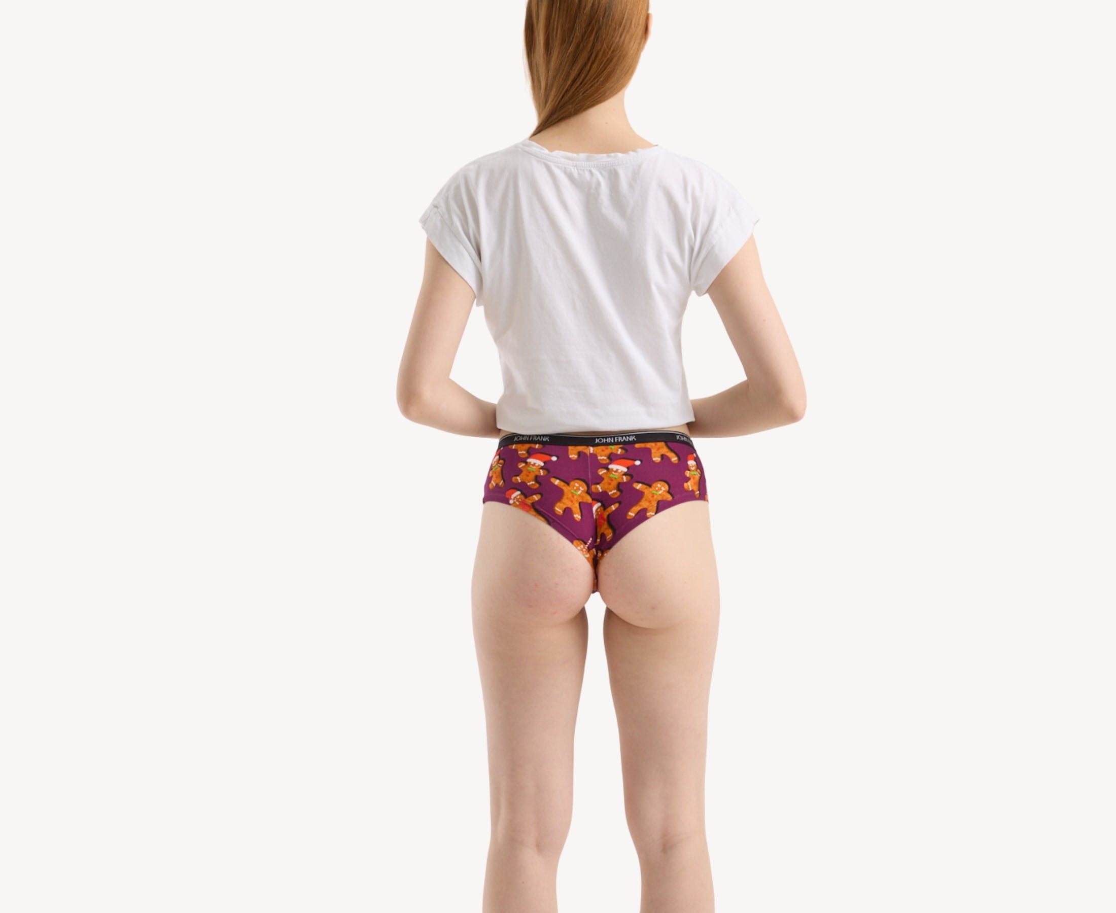 Back view of model wearing women’s 95% premium cotton hipster in purple with festive ginger bread cookies print, showcasing cheeky back.